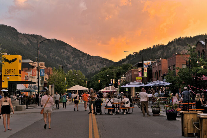 A vibrant city street at sunset with mountains in the background A vibrant city street at sunset with mountains in the background