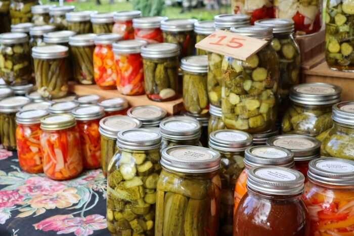 clear glass jars with kimchi and pickles at a food market