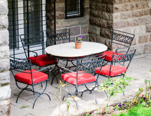 Cozy outdoor patio in Ankara with wrought iron furniture and vibrant red cushions, perfect for relaxation.