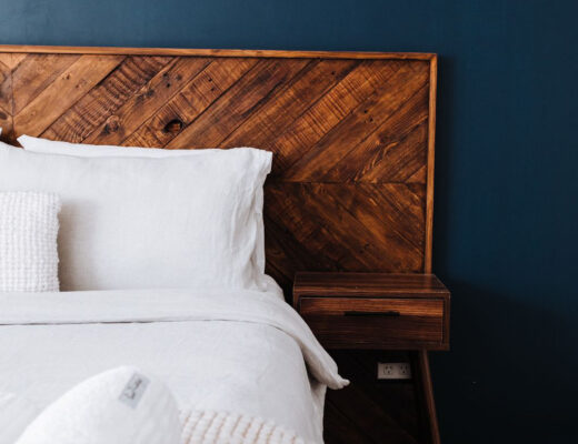 Modern bedroom showcasing dark blue wall, wooden headboard, and minimalist design