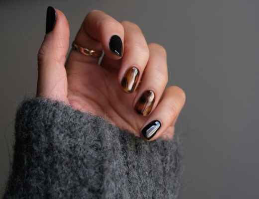 woman wearing rings and a dark manicure