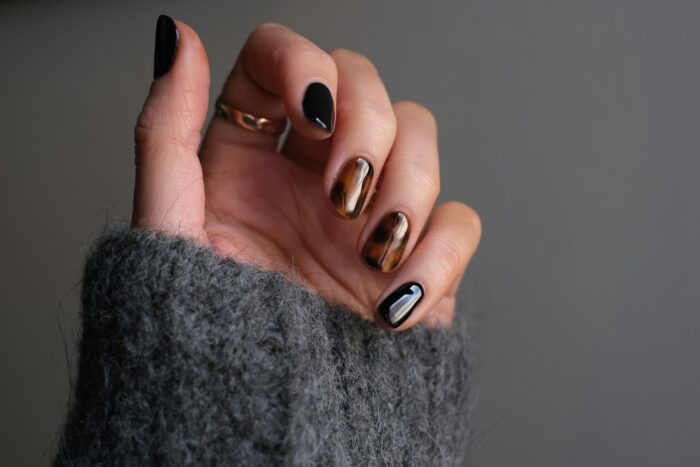 woman wearing rings and a dark manicure woman wearing rings and a dark manicure