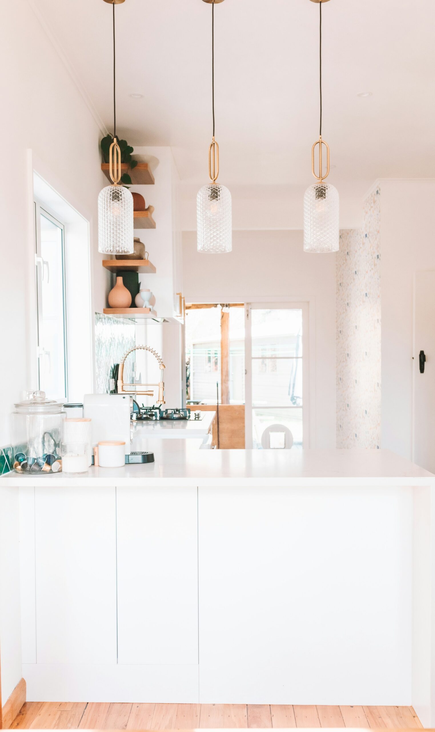 a kitchen wuth white counter tops, pendant lights and wooden floor a kitchen wuth white counter tops, pendant lights and wooden floor