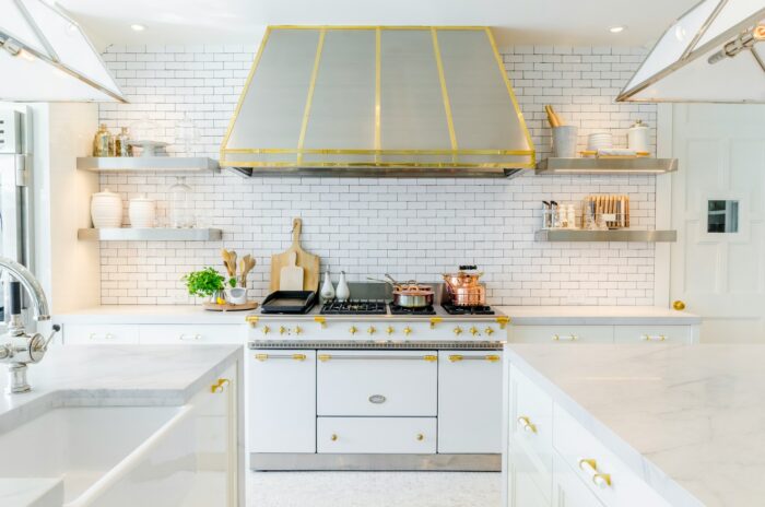 kitchen design with white cabinets with gold accents, large oven and stove hood kitchen design with white cabinets with gold accents, large oven and stove hood