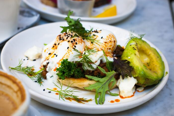 Delicious brunch featuring poached eggs, avocado, and herbs on a plate. Delicious brunch featuring poached eggs, avocado, and herbs on a plate.