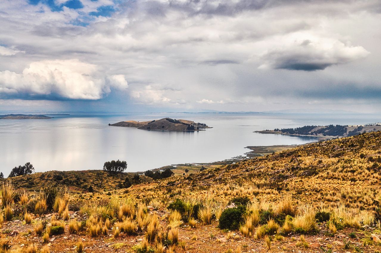 Breathtaking landscape of Lake Titicaca with a view of distant islands under dramatic skies.