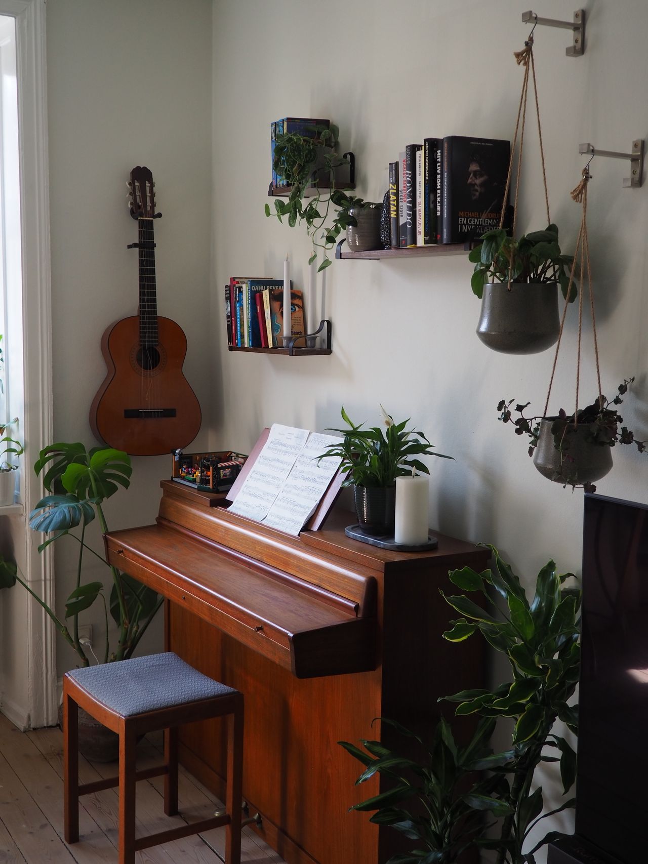 Inviting living space featuring a piano, guitar, and lush greenery in Scandinavian style Inviting living space featuring a piano, guitar, and lush greenery in Scandinavian style