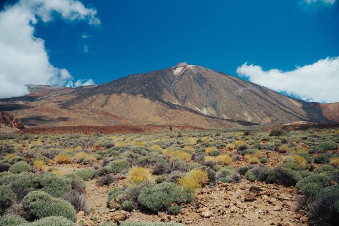 A stunning view of Mount Teide in Tenerife, with volcanic terrain and clear blue skies.